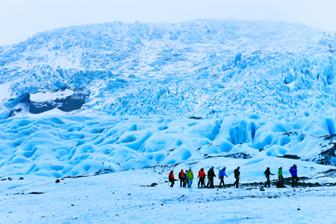 Groep toeristen loopt door ijslandschap in ijsland