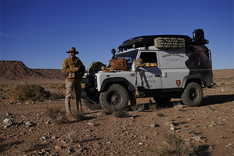 The Kings Elephant on rugged outdoor terrain with cowboy next door