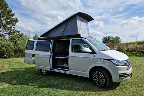 Woodpacker campervan met open deuren op grasveld